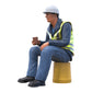 Product photo diorama and model building miniature figure: construction worker sitting on a bucket