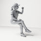 Diorama model-making product photo 3: Seated figure: female spectator with crossed legs & raised fist (B057)