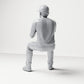 Diorama Modellbau Produktfoto 2: Sitzende Figur: Männlicher Zuschauer mit Kappe und zusammengeführten Händen (B068)