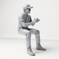 Diorama Modellbau Produktfoto 3: Sitzende Figur: Männlicher Zuschauer mit Kappe und zusammengeführten Händen (B068)